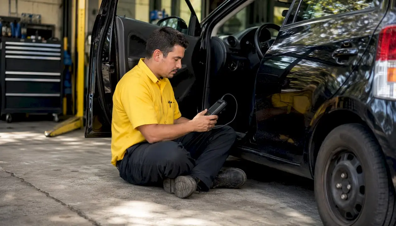 Mechanic scanning car with OBD-II diagnostic tool