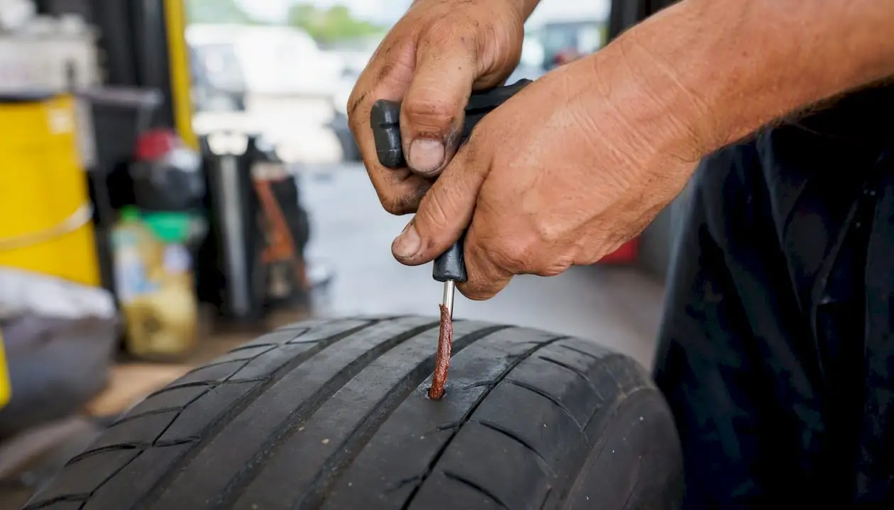 Hand inserting string plug tire repair