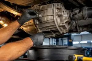 Technician servicing transfer case fluid