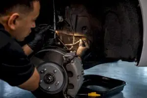 Technician inspecting brake fluid line