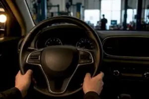 Driver holding vibrating steering wheel during diagnosis