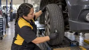 Technician inspecting uneven tire tread