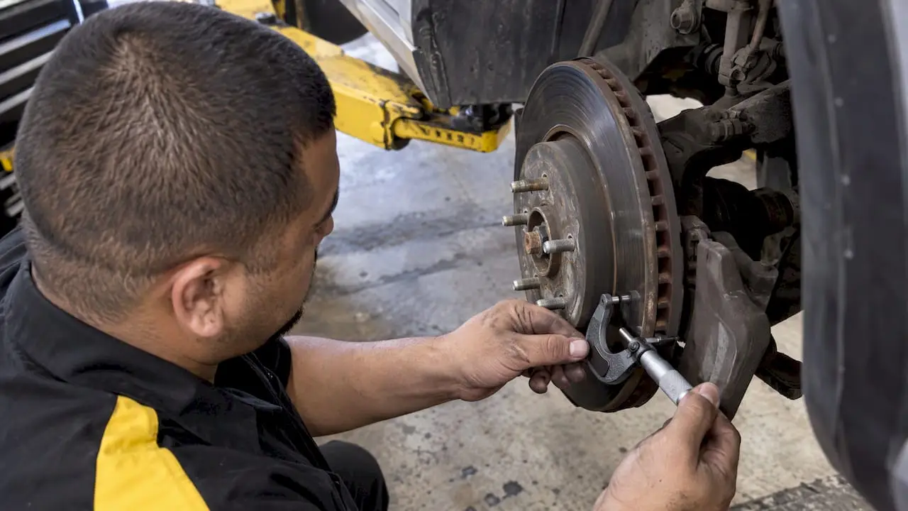 Technician measuring a brake rotor thickness