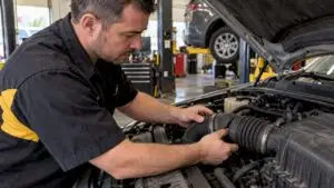 Technician inspecting a split engine intake boot