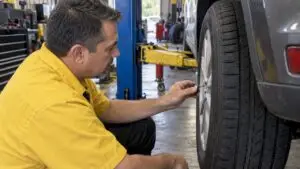 Technician measuring tread on a car tire