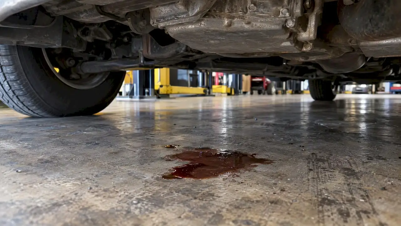 Reddish-brown fluid leak beneath a parked car